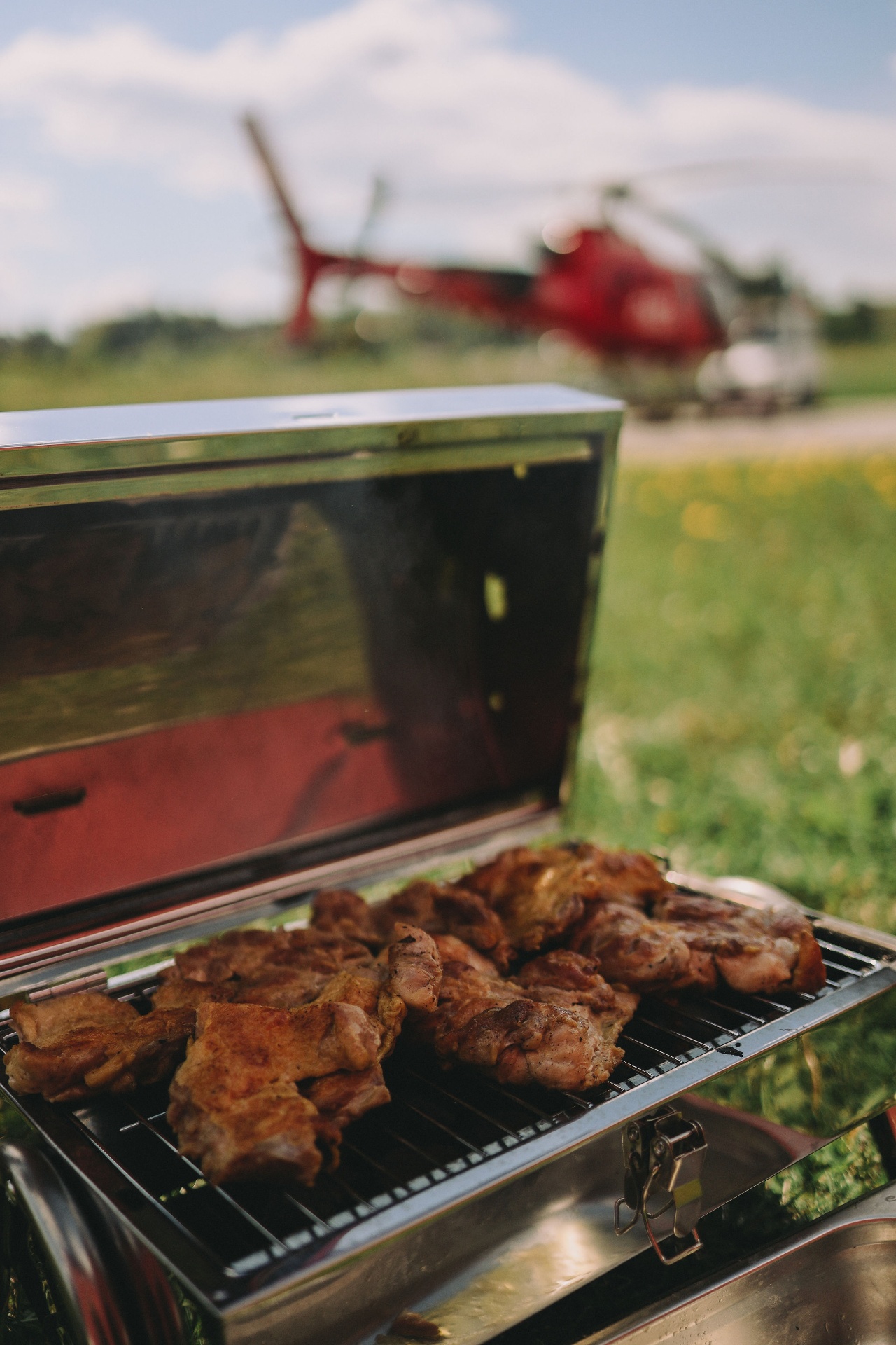 Grill being lit next to the helicopter – picnic on the wedding day