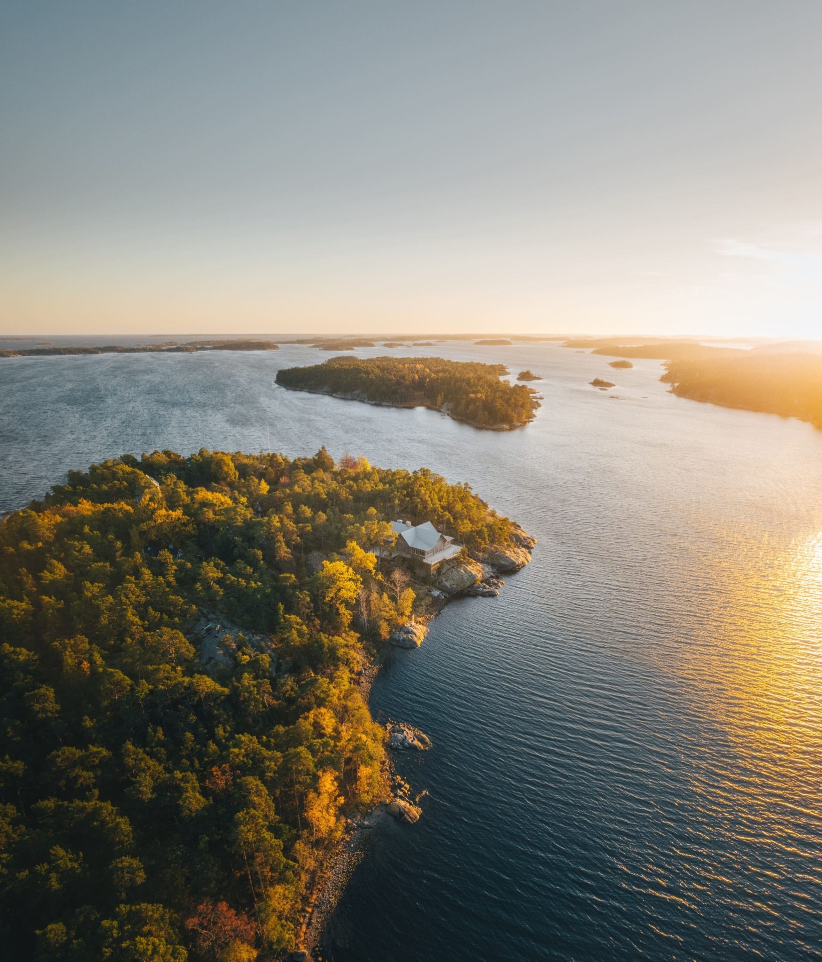 Idöborg i skärgården vid solnedgång med hus på klipphäll