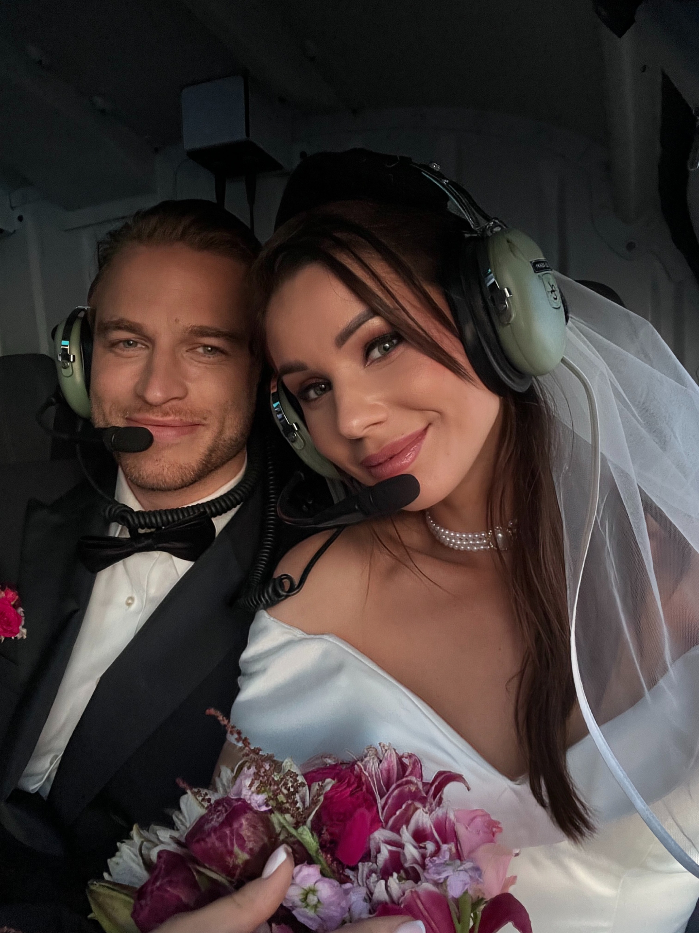 Newlyweds wearing headsets in the helicopter cabin
