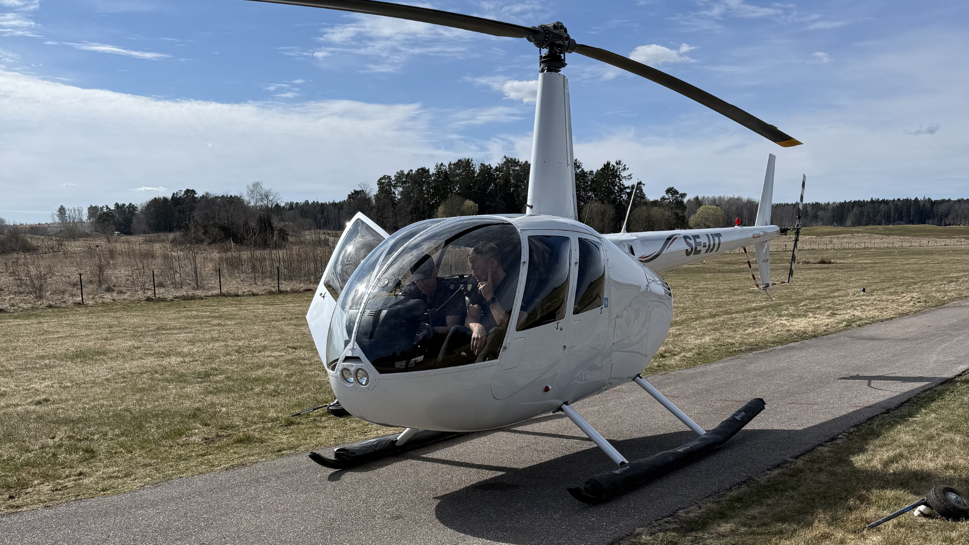 Robinson R44 at Åkersberga airfield with instructor and student