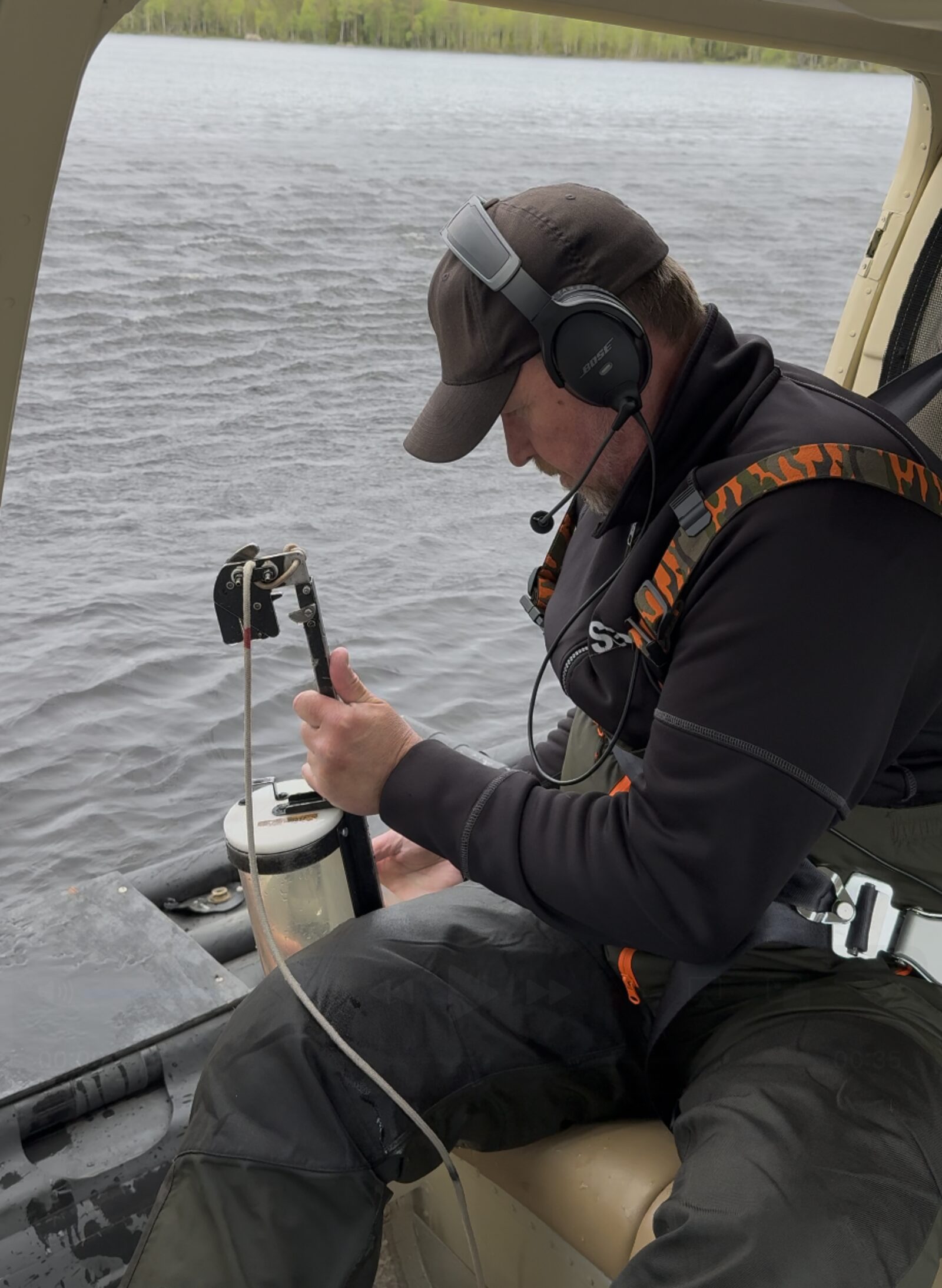 Accredited sampler taking a water sample from the helicopter
