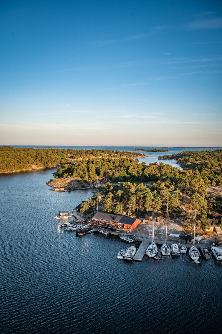 Harö hamn med båtar och skärgårdsrestaurang i kvällsljus