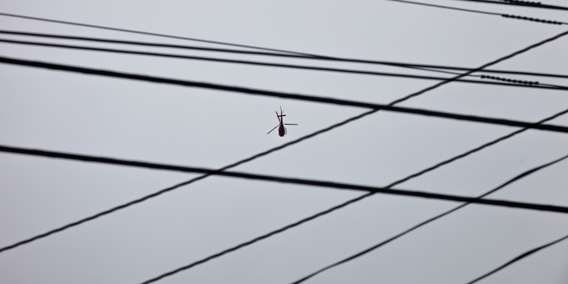 Helikopter mellan kraftledningar