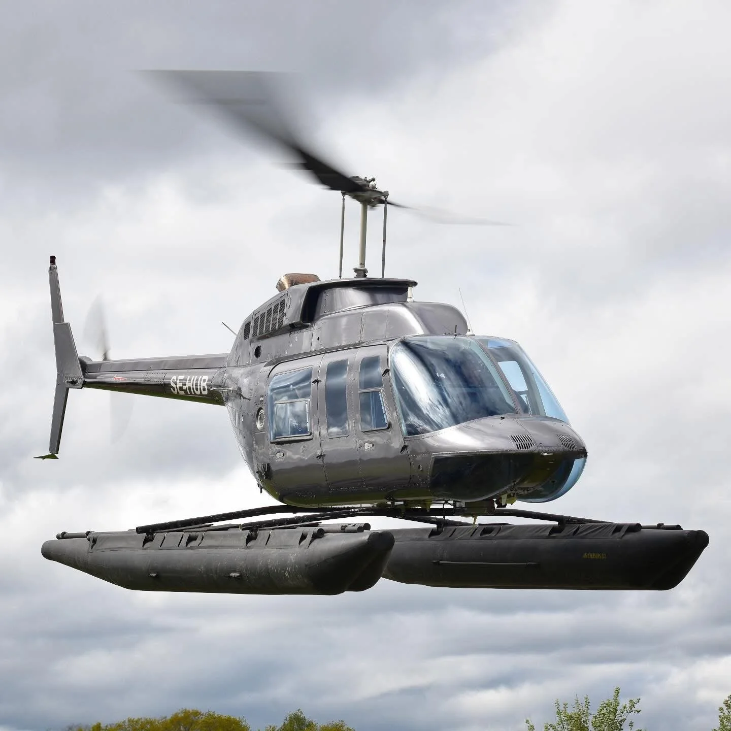 Bell 206L LongRanger SE-HUB with black floats in the air