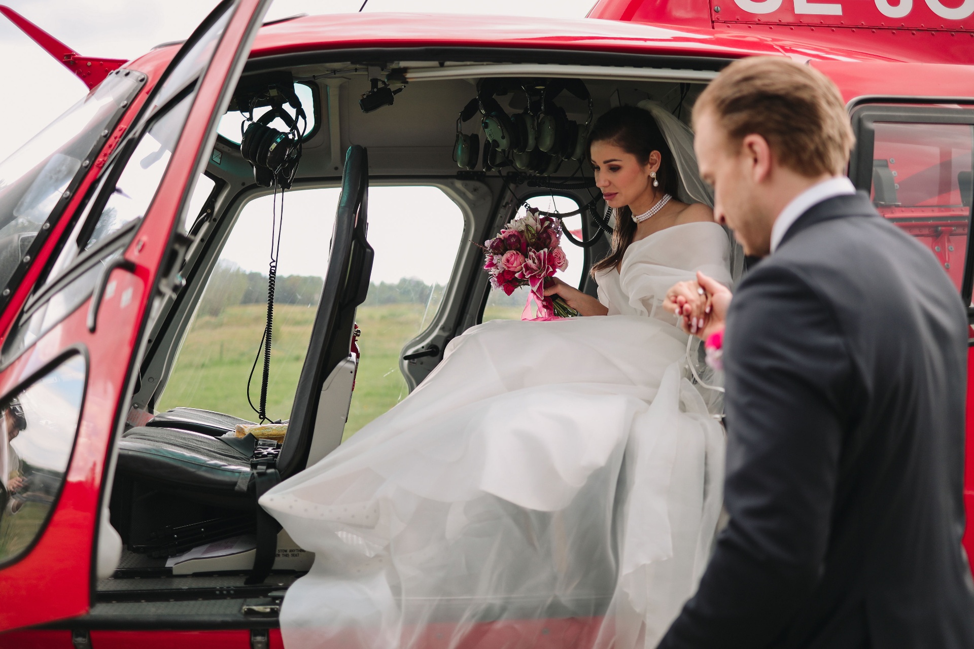 Bride being helped into the helicopter by her husband