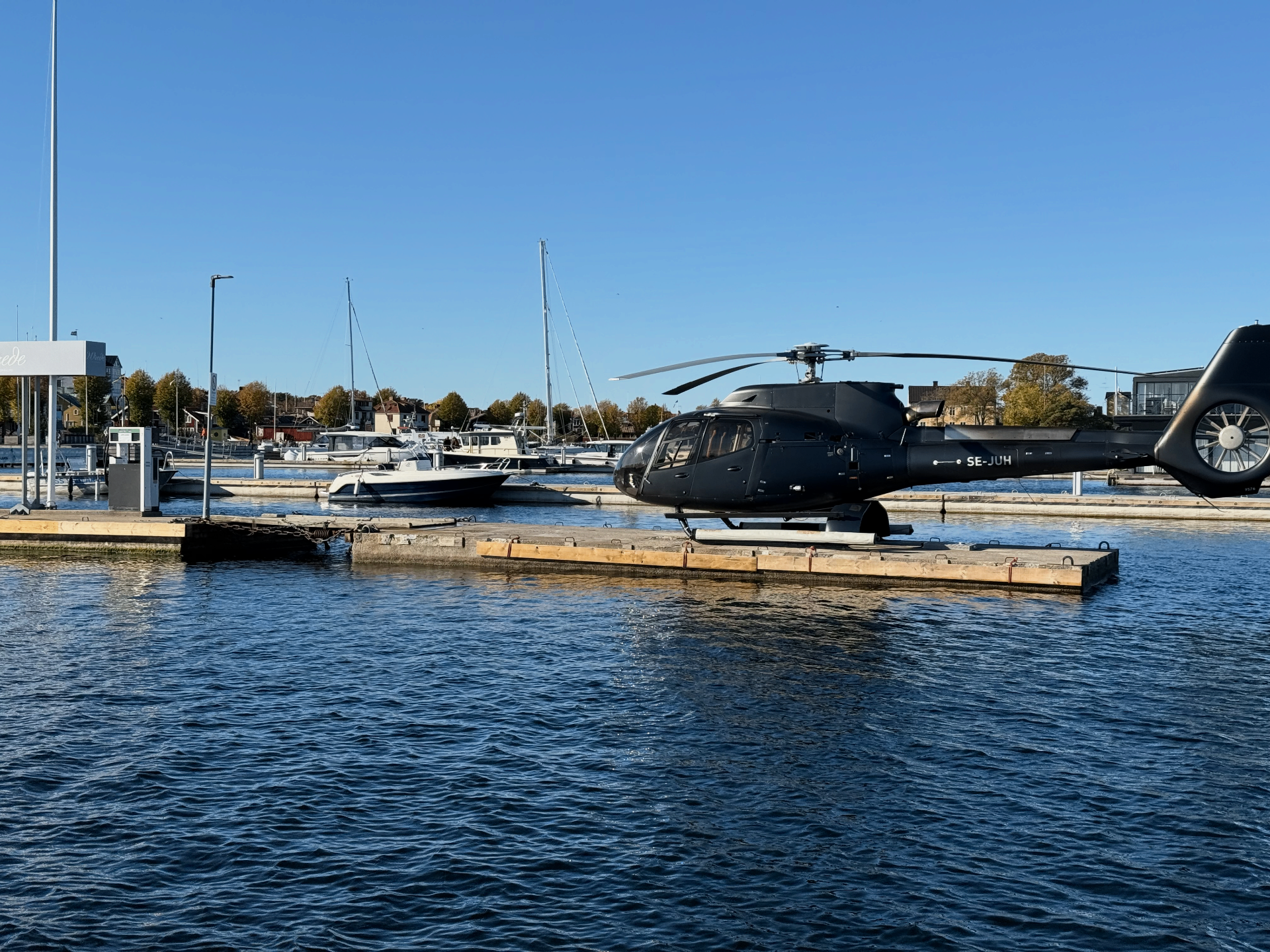 Svart helikopter SE-JUH på brygga i Sandhamns hamn